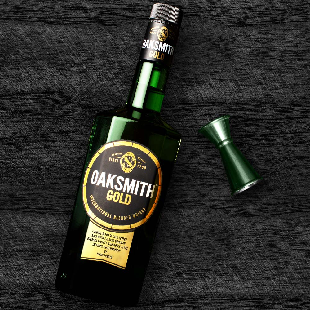 oaksmith gold bottle with jigger and peg measurer